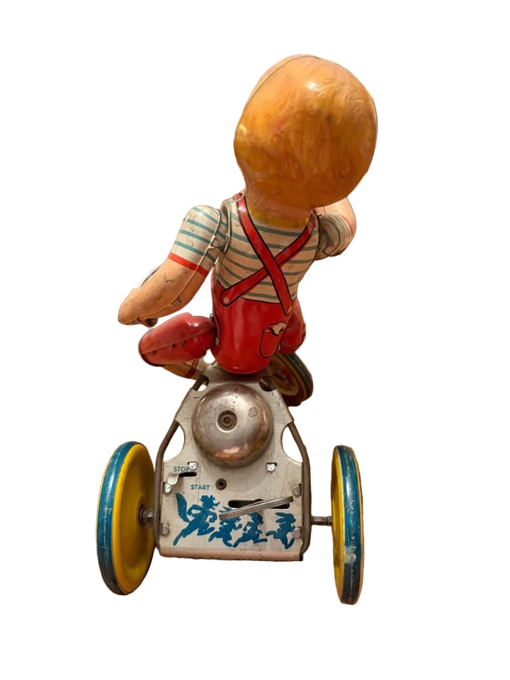 Antique wind up boy riding tricycle