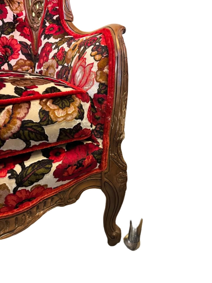 beautiful reupholstered wingback chair with ornate wood carvings of cherubs