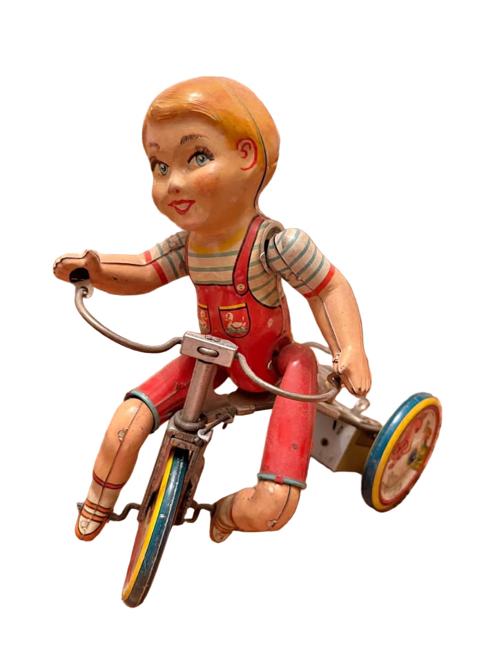 Antique wind up boy riding tricycle