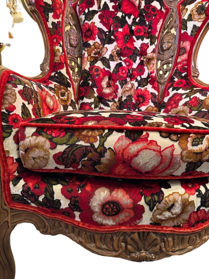 beautiful reupholstered wingback chair with ornate wood carvings of cherubs