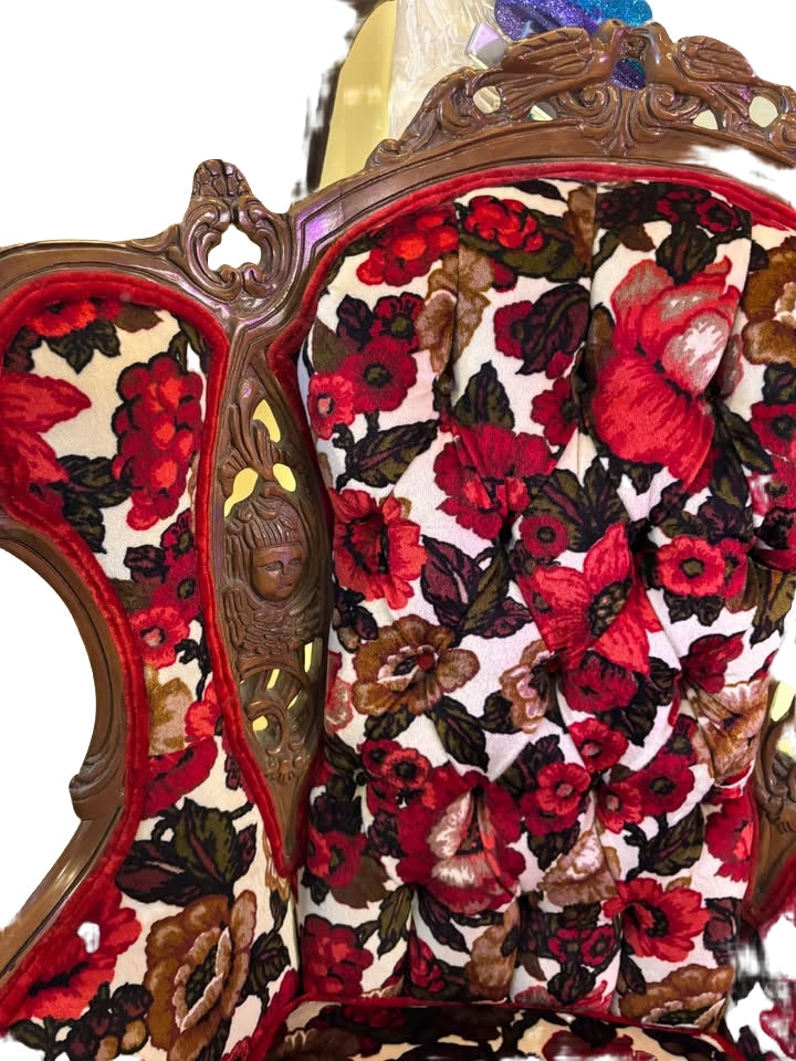 beautiful reupholstered wingback chair with ornate wood carvings of cherubs
