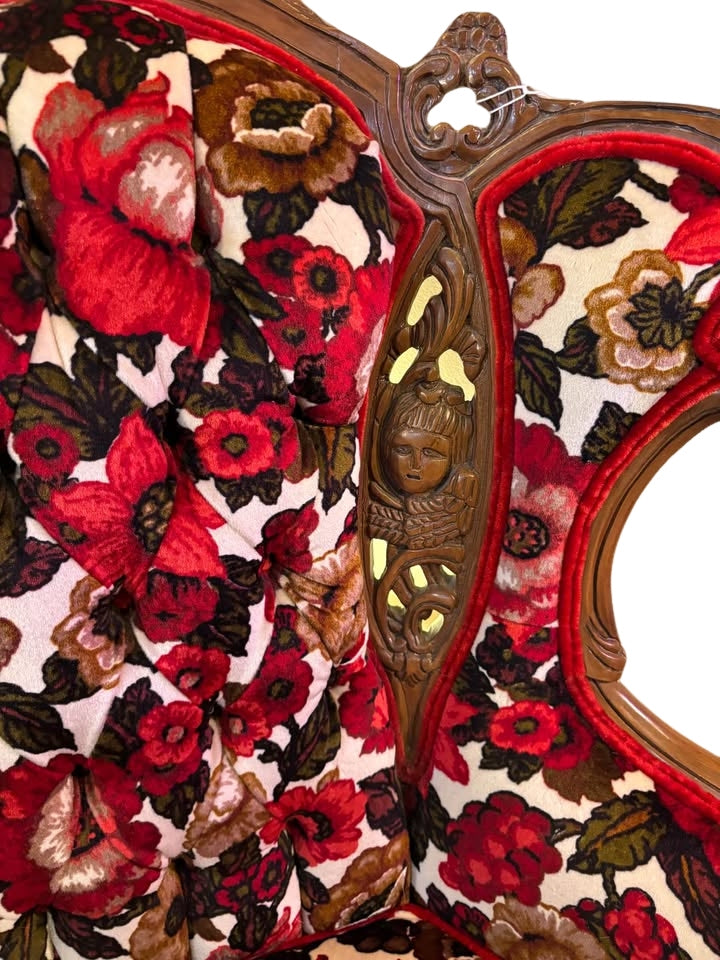 beautiful reupholstered wingback chair with ornate wood carvings of cherubs